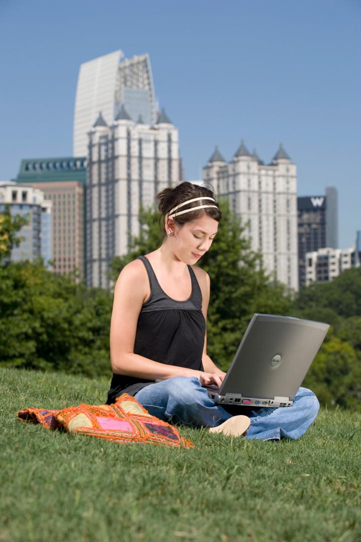 在线学生在城市公园外使用笔记本电脑