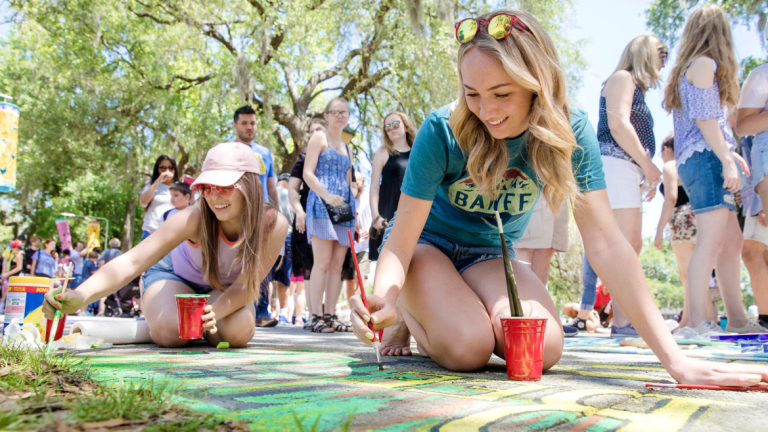 许多学生在人行道上用粉笔画艺术节