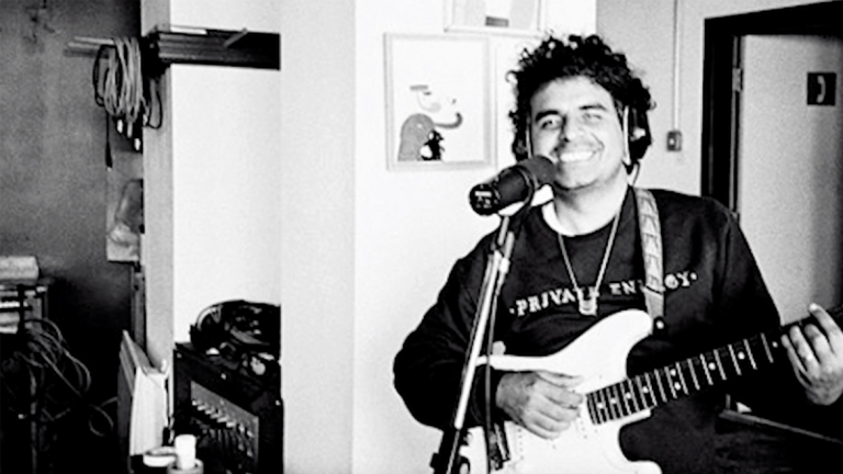 Musician Robert Carlos Lange, also known as Helado Negro, plays guitar in a studio.