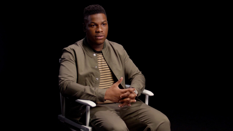 Still of young man sitting appearing to explain something